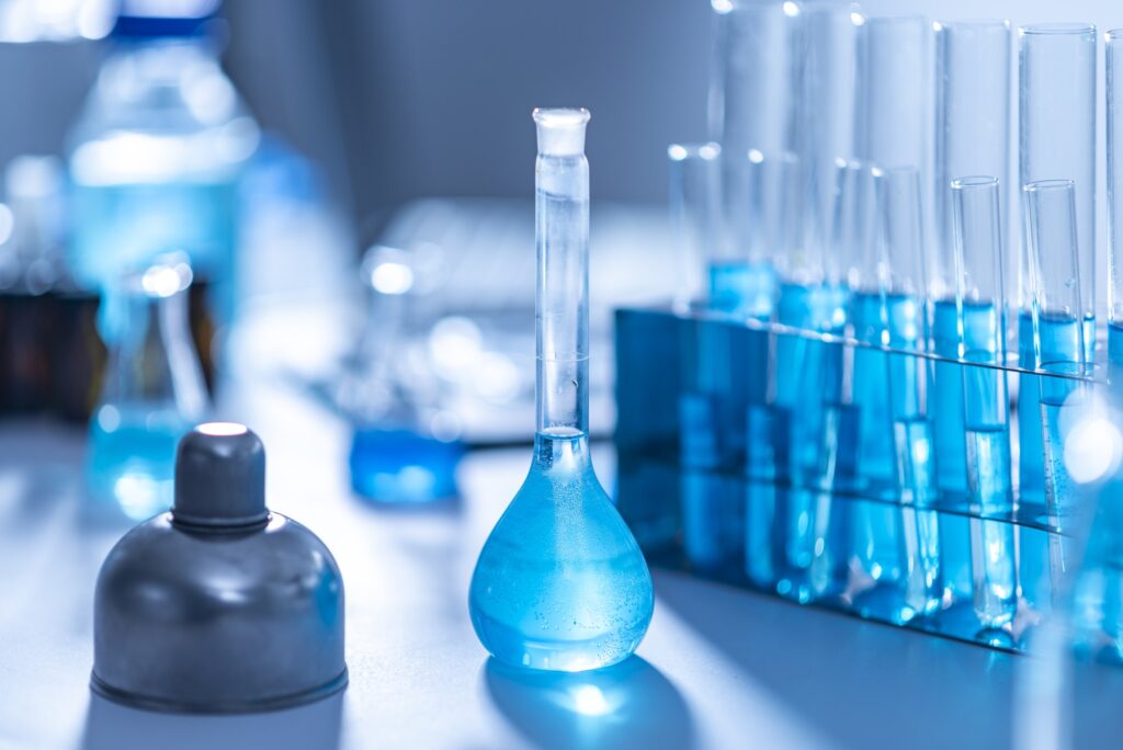 Researchers are using glassware and blue solutions in laboratories